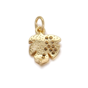Macro view of gold leaf pendant featuring textured metal and dark stone inlays