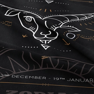 Detail of Capricorn zodiac print on black fabric showing date range and soft texture