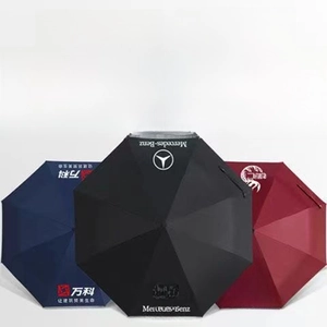 Detailed view of custom automatic folding umbrellas in navy, black, and burgundy with logo