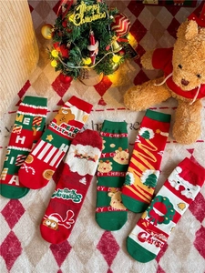 Detailed view of combed cotton Christmas socks featuring festive patterns on a plaid rug