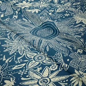 Dettaglio del tessuto mandala con intricati motivi bianchi su superficie blu scuro