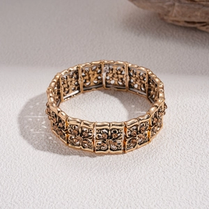 Detailed close-up of retro gold floral cutout bracelet with amber gemstone accents