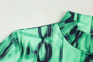 Close-up of the pleated high collar and stitching detail on a green printed dress