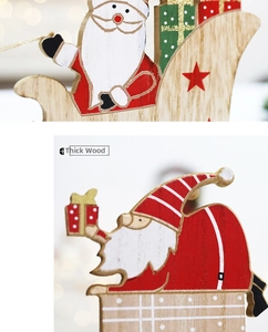 Close-up of thick wooden Christmas reindeer sleigh with painted Santa Claus figures