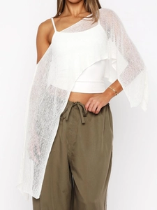 Detail of loose irregular knit poncho top paired with olive green wide-leg drawstring pants