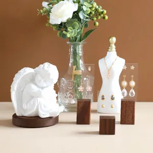 Elegant jewelry display rack featuring floral earrings and golden heart necklace on a model