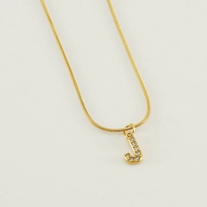 Detail of gold snake chain necklace with a rhinestone studded letter J pendant
