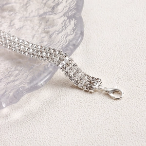 Macro shot of silver rhinestone bracelet with multi-row crystal pavé and lobster clasp