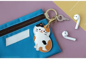 Détail d'un porte-carte chat calicot en cuir attaché à un sac en toile bleue robuste