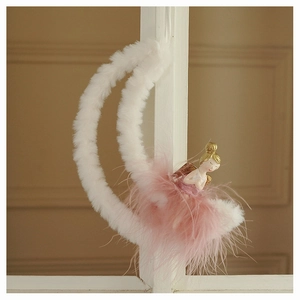 Detail of plush moon Christmas ornament featuring a fairy in a pink feather dress