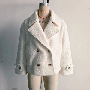 Detail of the white textured faux shearling coat showing lapel and double-breasted buttons