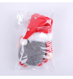 Vue détaillée d'un gnome de Noël avec chapeau rouge à paillettes sous emballage plastique
