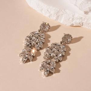 Gros plan d'élégantes boucles d'oreilles en feuilles avec cristaux scintillants