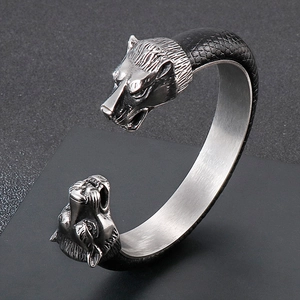 Detail of wolf head engraving and black scale texture on stainless steel cuff