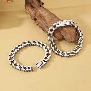 Vintage versilbertes Panzerarmband mit gravierten Mustern auf beigem Hintergrund