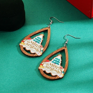 Detailed close-up of teardrop wooden Christmas earrings with snowman and tree motifs