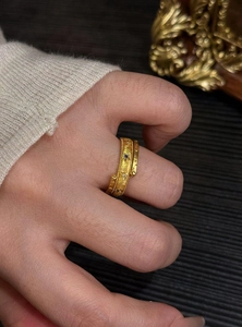 Detailed close-up view of a vintage style gold ring featuring star and sun motifs with zircons