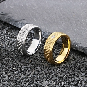 Detail of gold and silver grid-textured stainless steel rings with a single zircon inlay