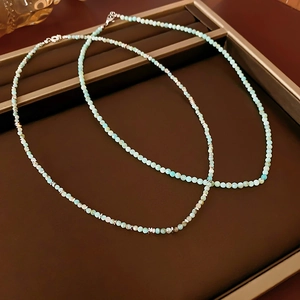 Detail of light blue amazonite beaded necklace with faceted silver spacers on dark tray