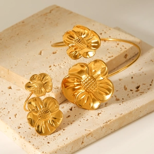 Macro shot of 18K gold plated stainless steel flower bracelet and adjustable ring set