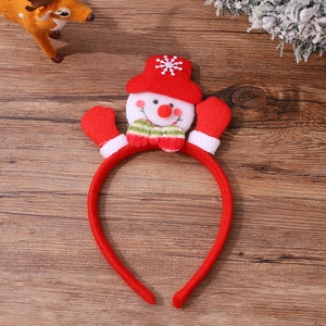 Detail of Christmas snowman headband with red hat and striped bow on wooden background