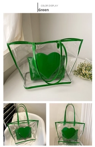 Detail of transparent PVC tote featuring green leather trim and heart shaped inner pouch