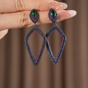 Macro view of vintage style drop earrings with blue, pink crystals and a green gemstone