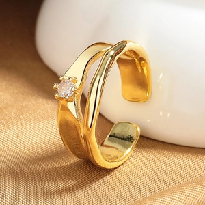 Close-up of gold double-layered wave ring with heart opal and clear zircon stone