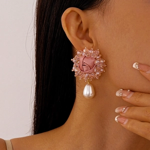 Detail of pink fabric rose earring with crystal beads and a white teardrop pearl pendant