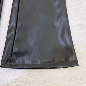 Dettaglio dei pantaloni in pelle PU nera liscia con cuciture resistenti ad ago singolo