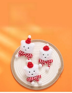 Detailed view of three plush white Christmas cat charms with red hats and striped scarves