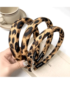Detail of leopard print headbands featuring 'HAND MADE' label and fabric texture