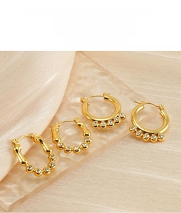 Detail of 18K gold plated stainless steel hoops with sparkling cubic zirconia on silk