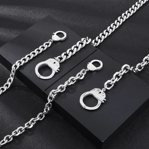 Détail de colliers gourmettes et chaînes en O en acier argenté avec pendentifs menottes