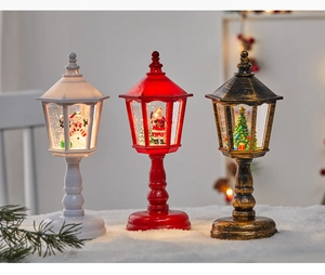 Trois lanternes de Noël avec Père Noël et bonhomme de neige sur une surface de neige