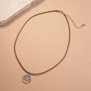 Detail of bohemian tree of life pendant with silver hollow design on brown wax cord