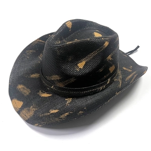 Detailed texture of black woven straw cowboy hat with vintage brushed tan patterns