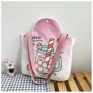 Detail view of pink gradient canvas tote bag with strawberry milk rabbit print and woven handles