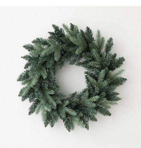 Nahaufnahme eines minimalistischen Weihnachtskranzes aus Piniennadeln an weißer Wand