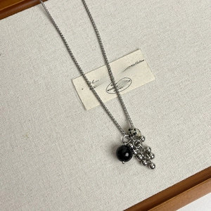 Détail du collier à chaîne argentée avec pierre noire et perles à motif marbre