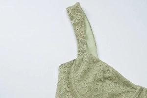 Dettaglio della spallina in pizzo verde e trama fine del vestito elegante scollato