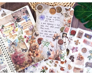 Flat lay of vintage scrapbooking paper set with floral, butterfly, and stamp motifs