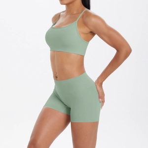 Vue latérale d'un ensemble de yoga vert sauge avec brassière à fines brides et short