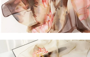 Detail of translucent silk scarf showing elegant ink floral patterns and soft texture