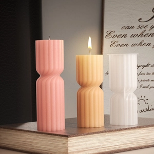 Vertical ribbed hourglass candle set on vintage books for cozy home decor styling