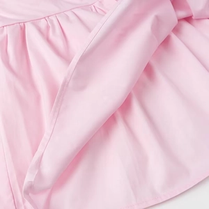 Detailed view of the smooth pink dress hem showing fine stitching and inner lining