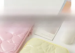 Detail of pink and yellow heart-quilted laptop sleeve with zipper and smooth nylon fabric