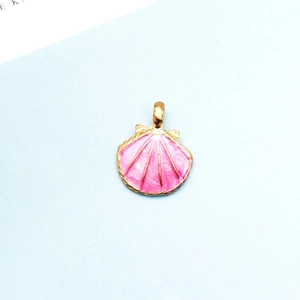 Makroaufnahme eines rosa Muschel-Anhängers mit Goldlegierung für DIY-Schmuckzubehör