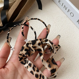 Detailed macro view of the handmade leopard print chiffon fabric and adjustable fastener