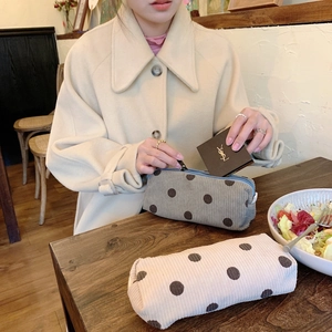 Detail of vintage corduroy polka dot makeup pouches in dark grey and beige colors